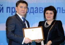 Награждение преподавателей вузов Аслан Саринжипов вручает Людмиле Лидер сертификат и памятный значок