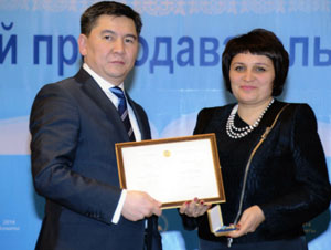 Аслан Саринжипов вручает Людмиле Лидер сертификат и памятный значок