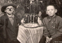 Рождество: о чём поведали музейные экспонаты 1.1.87 Дети у новогодней ёлки. Один из мальчиков в маскарадном костюме. На столике блюдо с печеньем (?), два целлулоидных петушка, игрушечный баян. 1950-е гг.,