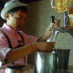 Lederhosen und bayrischer Hut: Die jungen Kellner auf dem Oktoberfest in traditioneller Kleidung.