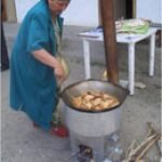 Frau kocht auf energieffizientem Kochofen.