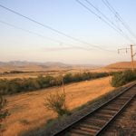 Endlich_ die ersten Ausl&auml;ufer der Berge strahlen im Glanz der Abendsonne. Der Schaffner zeigt mir stolz seinen Heimatort.