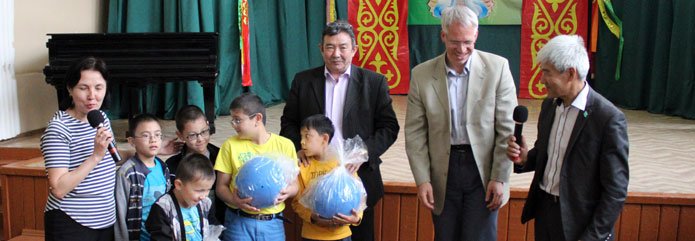 Musrjat Elibakijev und Kulturattache Raban Richter (v.r.) überreichten den Schülern der Ostrowski-Schule drei Goalbälle.