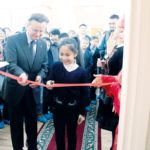 Dr. Bernhard Lauer und ein junger Grimm-Fan zerschneiden feierlich das rote Band.